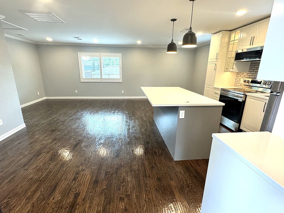 View from the front door looking at the kitchen, gorgeous hand-scraped hard wood floors and terrific lighting. The bathroom and walk-in closet are located to the left of the photo.