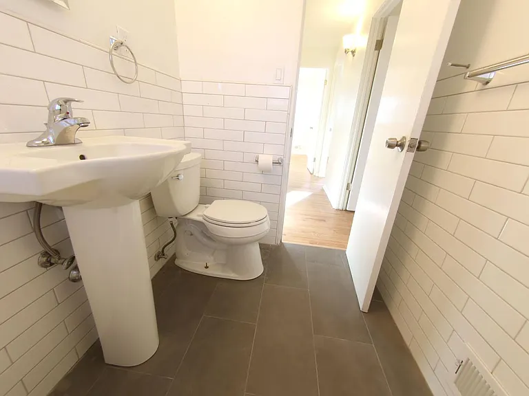 Fully Remodeled Bathroom looking towards upstairs hallway. Note- Kohler Fixtures, subway tile, and slate grey floor tiles.