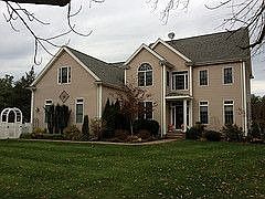 Front View with mature landscaping, outdoor uplighting, and sprinkler systems.