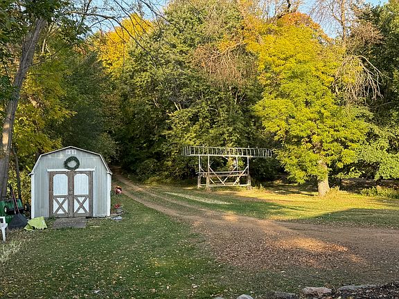 Full tree covered driveway and yard area