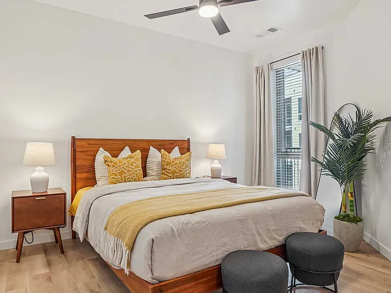 Unwind in a thoughtfully designed bedroom featuring warm wood accents, soft natural light, and contemporary furnishings.