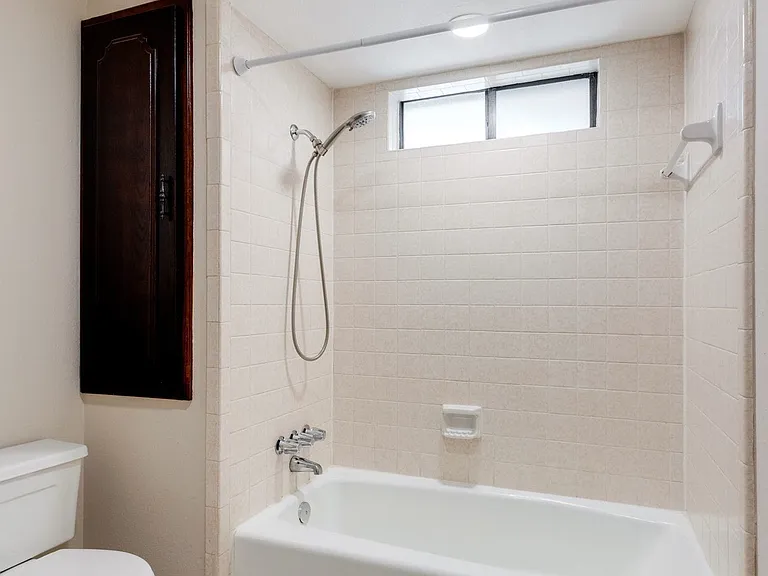 This is the separate shower area with a toilet. There are two large cabinets for storage. The left cabinets are not shown.