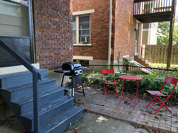 Good sized paver patio with overhang looking out onto fenced in yard.