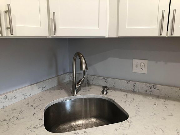 New sink and delta faucet with sprayer features and a soap dispenser.