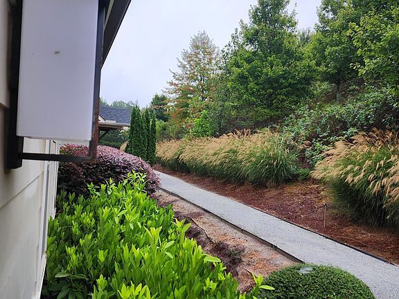 Front door view shows landscape and walking path to the left