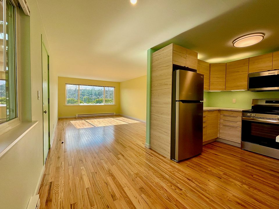 Newer kitchen and spacious living room with hardwood floors and large west facing windows. (Picture is of similar apartment one floor up.)