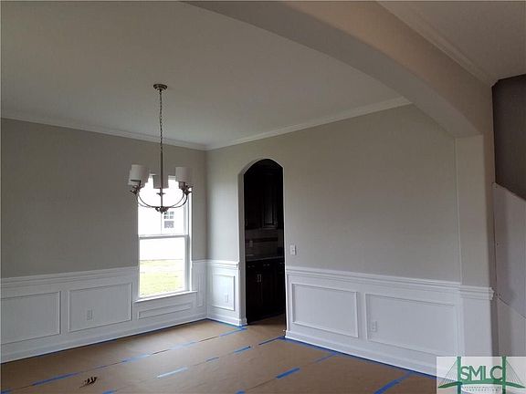Arched openings and beautiful trim work adorn this large dining area