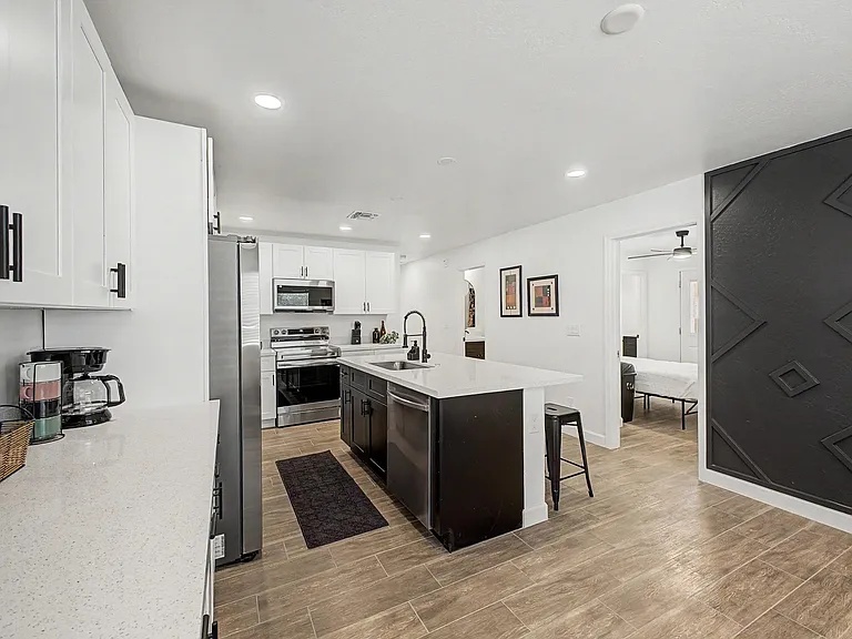 Open kitchen with large island, quartz-style counters, and stainless steel range, microwave, and fridge for easy meal prep.