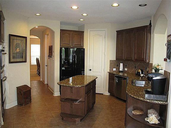 This GOURMET island kitchen boasts GRANITE countertops, under mount sink, STAINLESS STEEL appliances, and tile floor & backsplash!