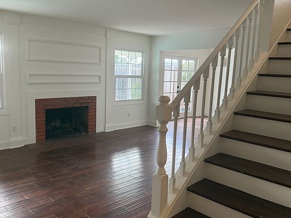 View from front entry into living room with wood burning fireplace, and dining room (with French doors to back yard)