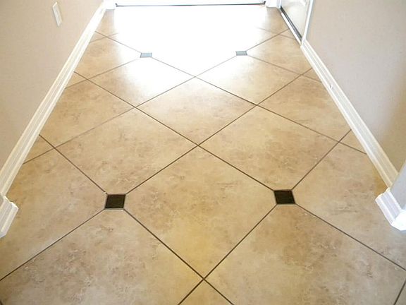 NEUTRAL YET ELEGANT 18" PORCELAIN TILE WITH GRANITE ACCENTS CAN BE FOUND IN THE ENTRY, KITCHEN & DIN