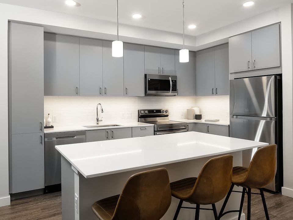 Modern kitchens with light grey cabinetry, white quartz countertops, stainless steel appliances, and hard surface flooring