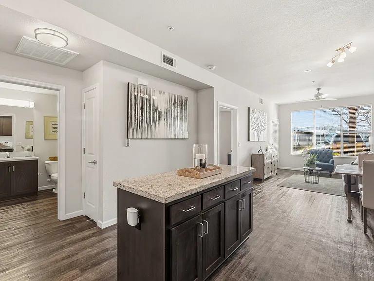 Aspire Apartments Tracy California A modern kitchen with dark wood cabinets and a granite countertop.