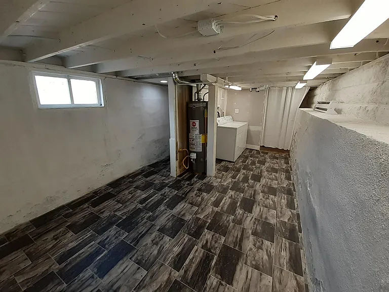 Well-lit basement Laundry room with extra storage.