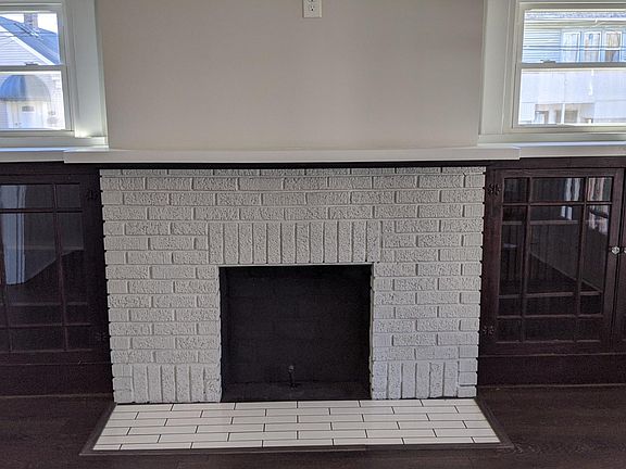 Step into this lovely front room. Fireplace does not work, but serves as a design feature. Lovely wooden cabinets book-end the gorgeous fireplace. Windows galore let the natural light flow into this entire house.