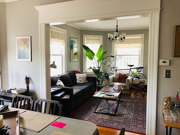 Dining room view into living room - both large and light filled with abundance of windows