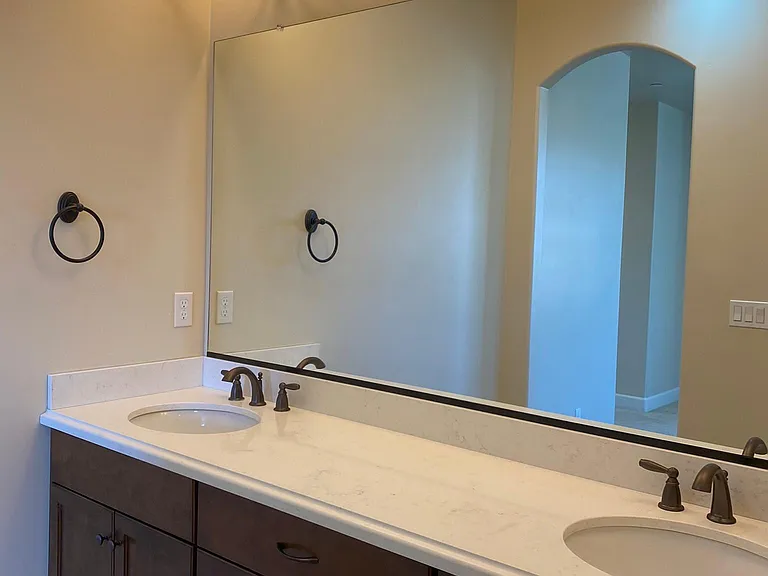 Dual-sink vanity with quartz countertop and generous storage.