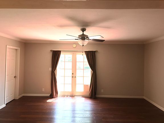 View of Family room with french doors leading to the backyard; entrance to master bedroom to the left