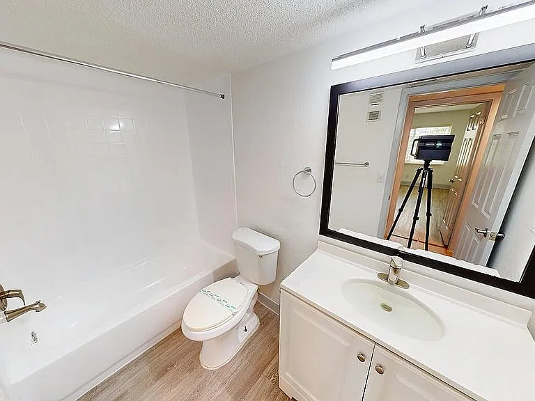 Bright bathroom with modern fixtures, featuring a sleek bathtub, elegant vanity, and large mirror, ideal for stylish living.