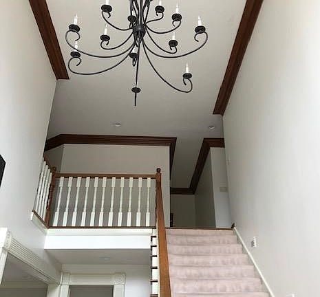Grand light fixture and beautiful space. Back hall staircase down the back side of the house.