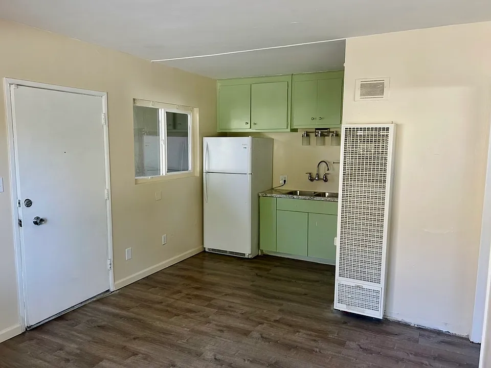 Living room looking to front door and kitchen