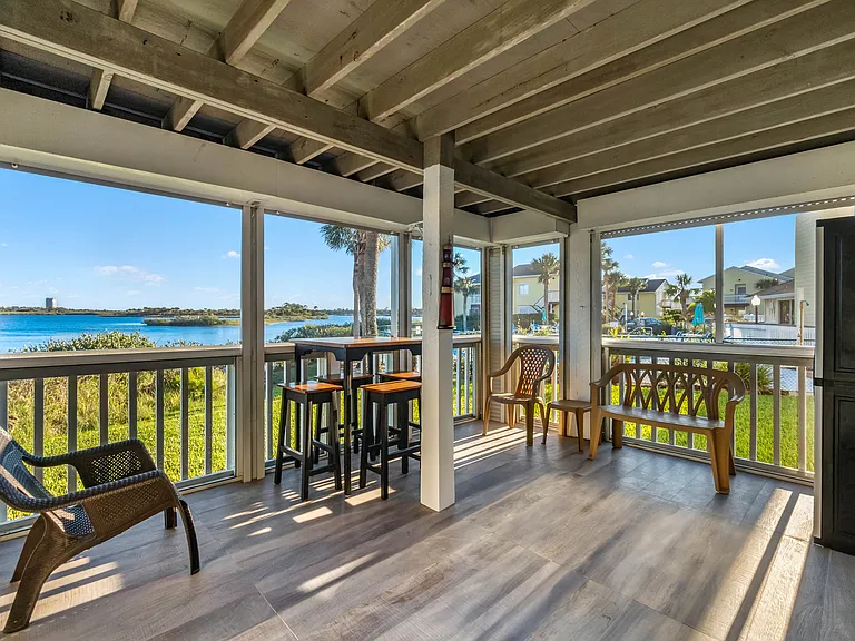 A large screened-in porch with views of the Intracoastal Waterway and the sparkling solar-heated pool.