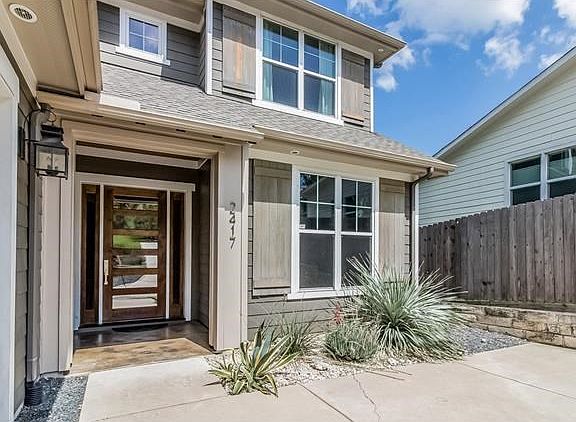 Entry is accented by heavy wood and glass door that enhances the natural light of the interiors.