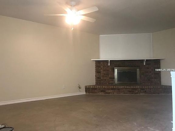 The living room has a wood burning fireplace and new ceiling fan