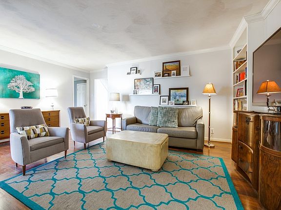 Cozy Mid-Century living room with gas log fireplace and built in bookshelves plus the easy care laminate flooring.