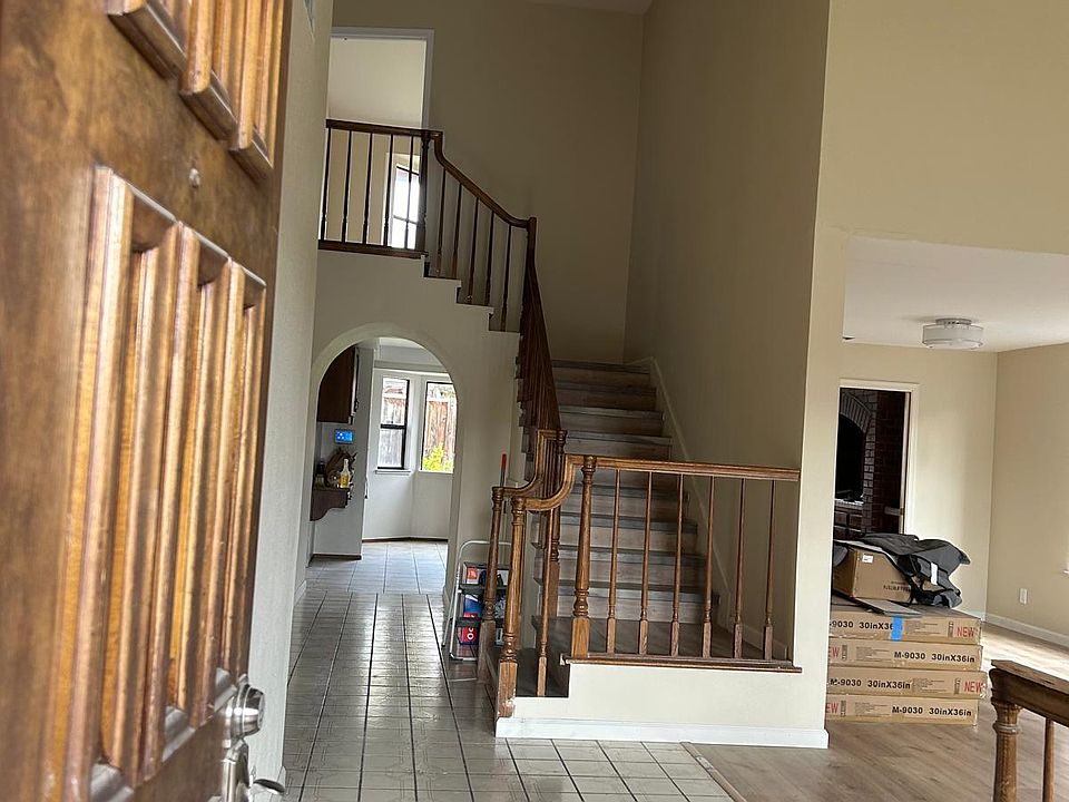 Entry - from front door. Chandeliers hanging from above. Stairway present in center of house. Kitchen ahead under the arch.