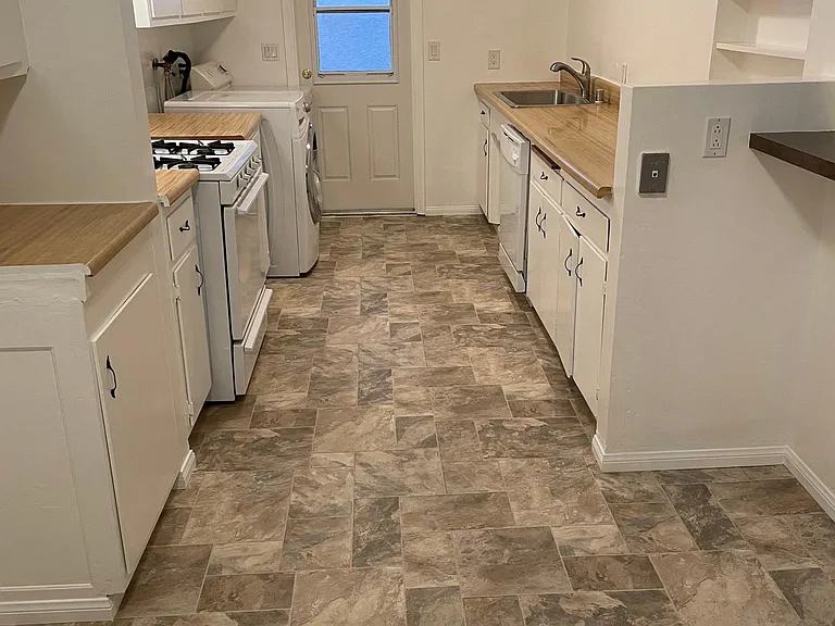 Large alley kitchen with stove, washer/dryer, dishwasher.