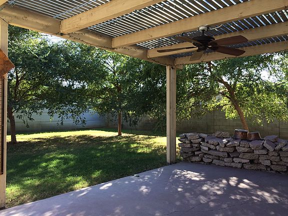 Trellised patio cover overlooks tree-covered backyard