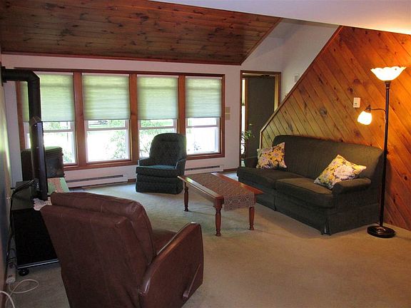 Wood covered, cathedral ceiling.  Carpeted.  Gas stove. Lots of natural light.