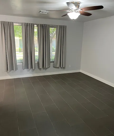 Living Room: Front Window, New Curtains, Tile and Grout Flooring, Freshly Painted Ceiling, Walls, Baseboards, Doors and Moldings, Ceiling Fan with Light.
