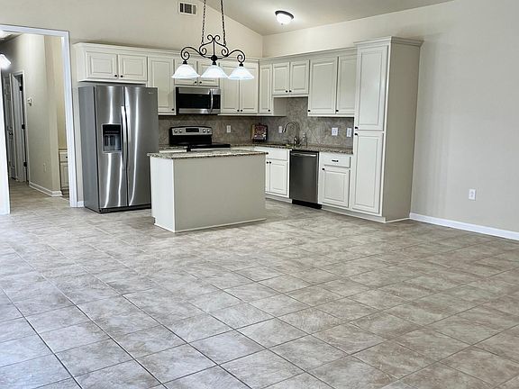 Kitchen area is part of living space with vaulted ceiling.