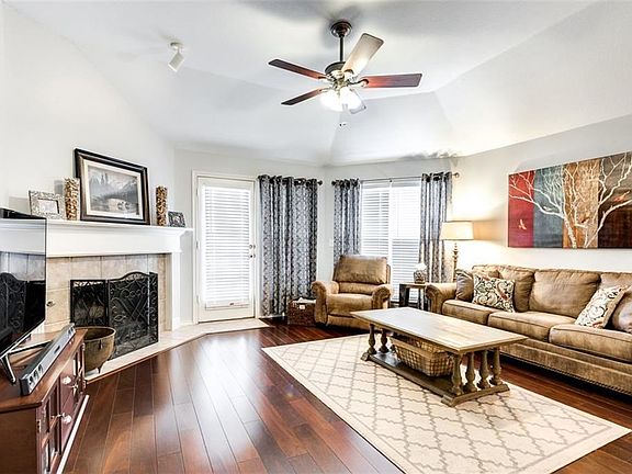 Engineered wood floors lead from foyer into family room. Vaulted ceiling with modern fan. Corner wood burning fireplace. Attractive window coverings. Fresh paint. Undated, NO popcorn ceilings! Door leads to backyard.