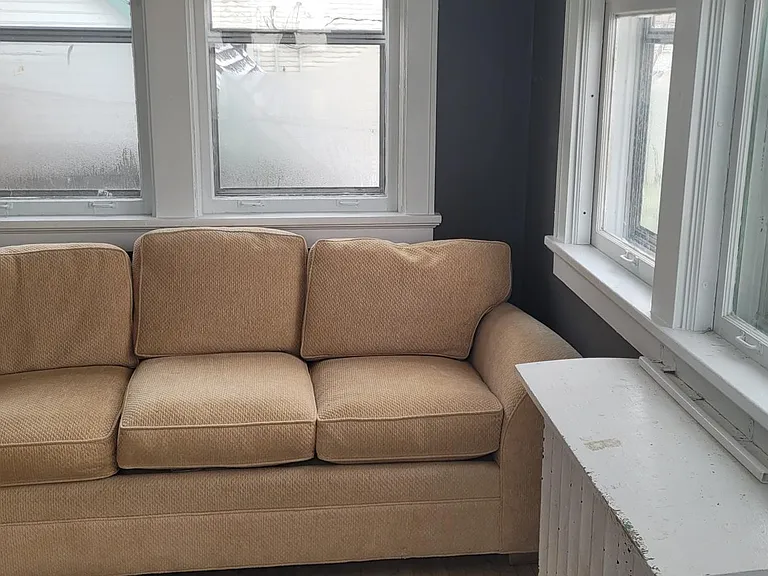 2nd bedroom on 2nd floor, room 2 with couch on one end and TV on the other end of sun room.