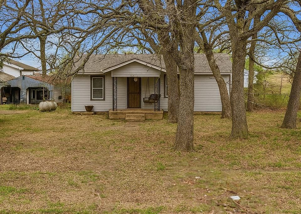 Bungalow-style home featuring roof with shingles and a front yard
