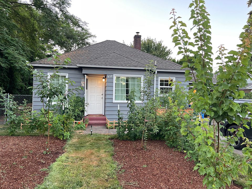 Front of house with fruit trees and raspberry bushes