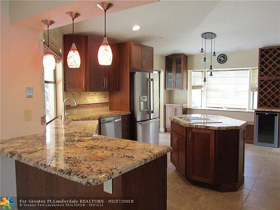 Kitchen has Wood cabinets, Granite Counters, Stainless appliances, center Island and snack bar that opens to Great Room/Family R