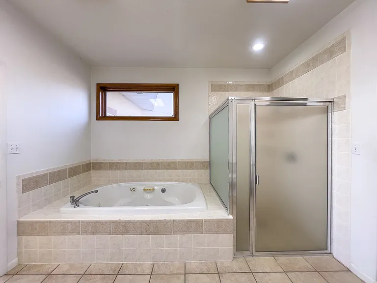 The primary bedroom suite, features this large soaking tub as well as walk-in shower.