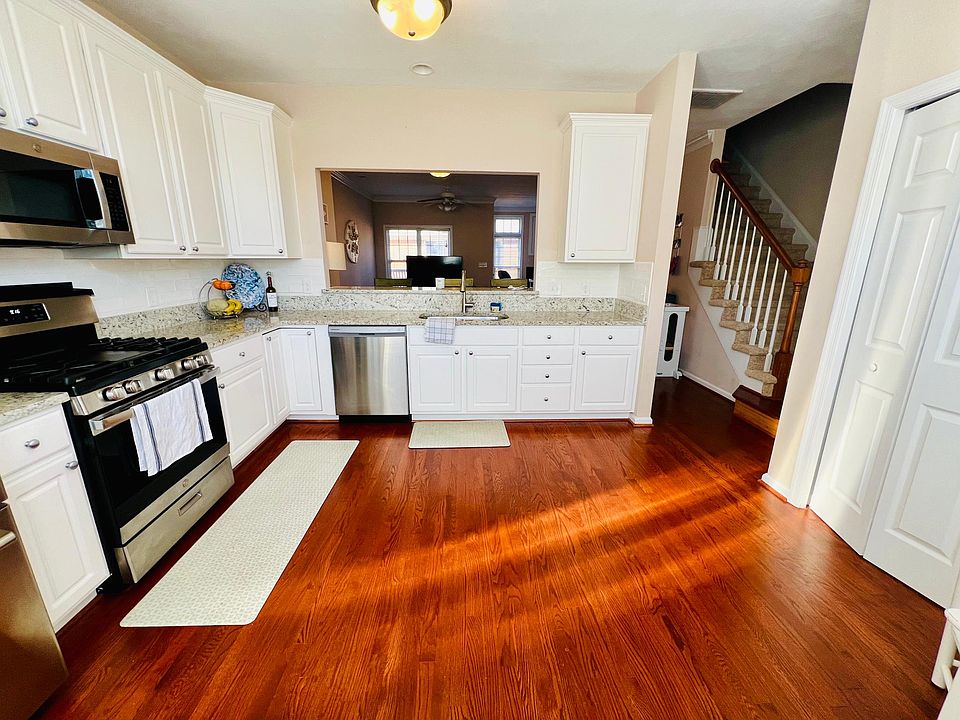 Kitchen overlooks living room with stairwell to third floor