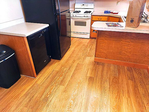 Kitchen with stove, refrigerator, built in microwave and dishwasher.