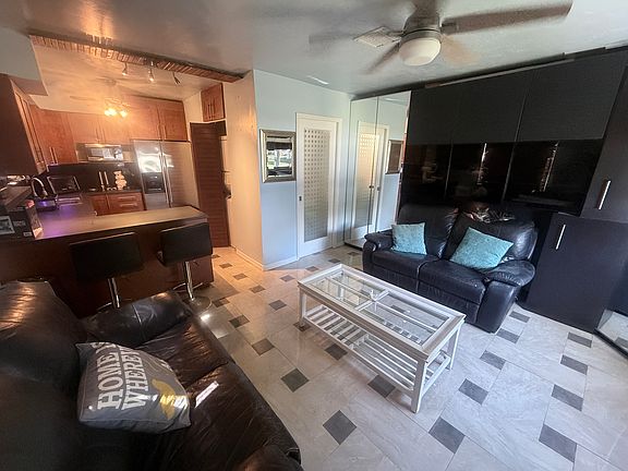 View of entire studio from inside frm the entrance. (L) Kitchen (middle) bathroom, (R) closets with mirror doors.