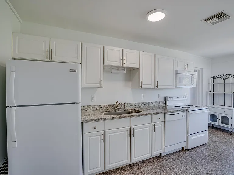 Large eat-in kitchen with granite counters, terrazzo floor, and ceiling fan. Access to 3/4 bath.
