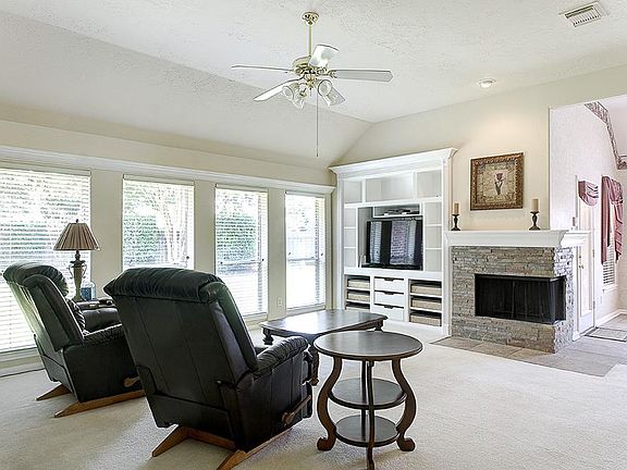 Light and bright family room features built-ins, corner fireplace and open access to dining room and