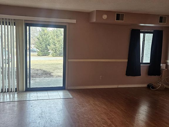 Looking into spacious living room from apartment entrance.