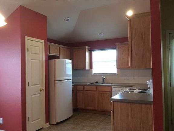 The kitchen features a large pantry, recent dishwasher and range, built-in microwave and a refrigerator.  Note the high ceilings and eyeball spots!