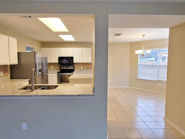 Living room looking into the kitchen bar area and breakfast area.