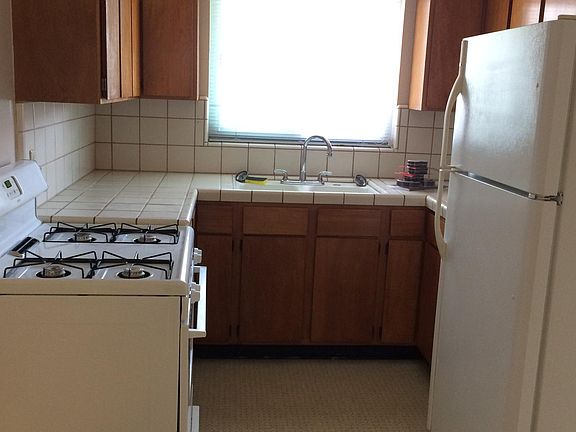 Kitchen with stove and refrigerator. Refinished cabinets.